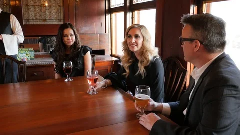 Group of adults talk at table with drinks on boxcar train camera still Stock Footage 117849251
