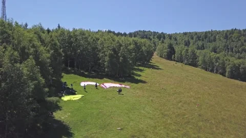 Group of adventurers stands on the launch site preparing for flight while Stock Footage 255755717