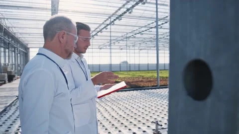 Group of agronomists using tablet computer to collect important data walking in Stock Footage 139723115