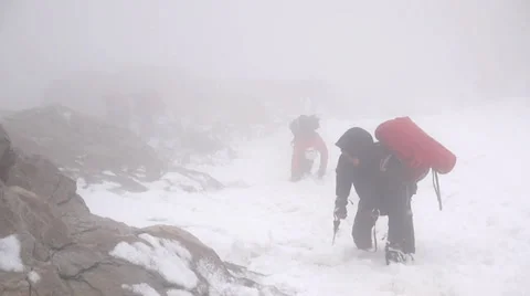 Group of Alpine Climbers descending steep snow covered mountain in fog Stock Footage 43248804