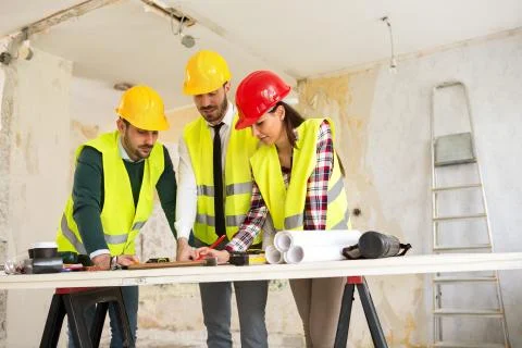 Group of architects consult about the project on construction site Stock Photos