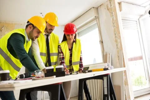 Group of architects consult about the project on construction site Stock Photos
