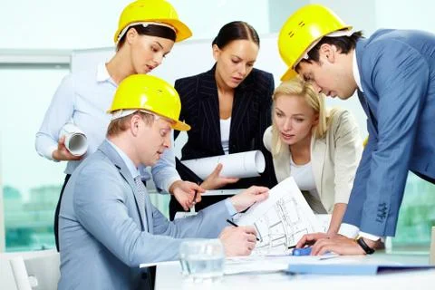 Group of architects discussing draft of new construction Stock Photos