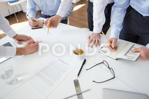 Group of architects planning their work by desk Stock Photos