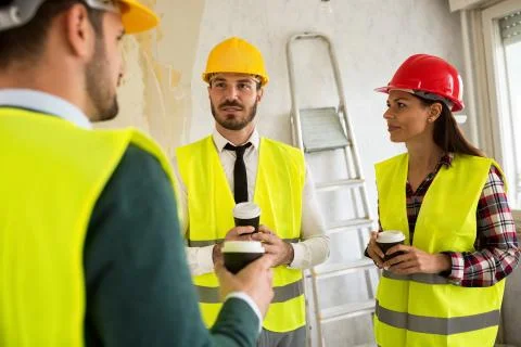 Group of architects talking on coffee break at construction site Stock Photos