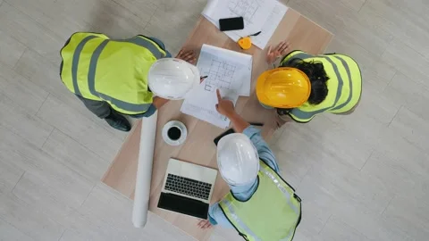 Group Architects working on plans with a blueprint Stock-Footage 150473856