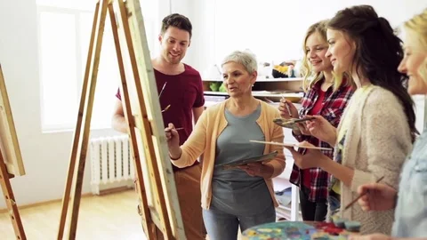 Group of artists discussing painting at art school Stock Footage