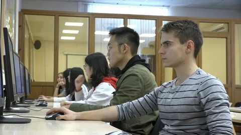A group of Asian and European students use computers in the classroom Stock Footage