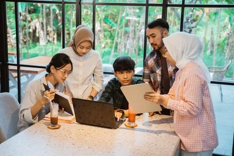 Group of asian students using a tablet and a laptop Stock Photos