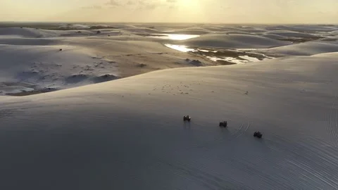 Group of ATVs Crossing Wet Sand Between Lagoons in Lençóis Maranhenses Stock Footage 342446188