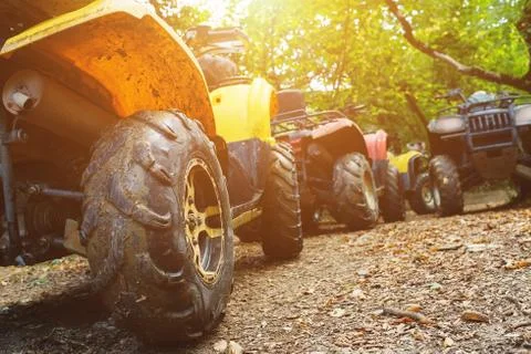 A group of ATVs in a forest covered in mud. Wheels and elements of all-terrai Stock Photos