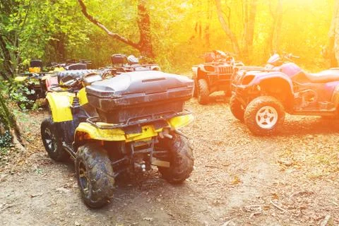 A group of ATVs in a forest covered in mud. Wheels and elements of all-terrai Stock Photos
