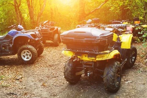 A group of ATVs in a forest covered in mud. Wheels and elements of all-terrai Stock Photos