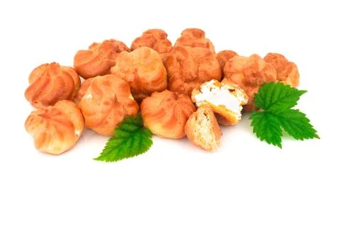 Group of baked eclair, custard, cake, profiterole, bread with green leaves. I Stock Photos