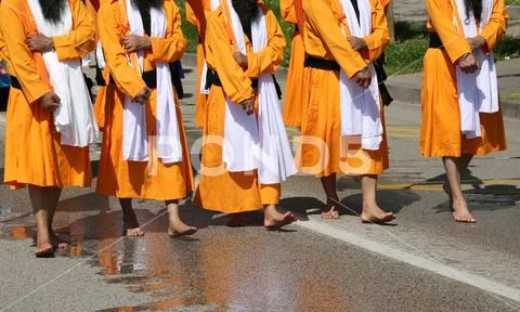 Group of barefooted people with orange dresses during the religious Sikh even Stock Photos