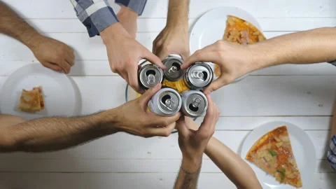 Group of best friends sitting at the table and clicking aluminum cans with soda Video stock 165748834