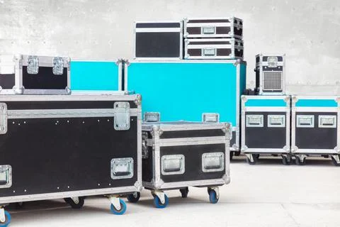 Group of black and blue flight cases on a concrete floor Stock Photos