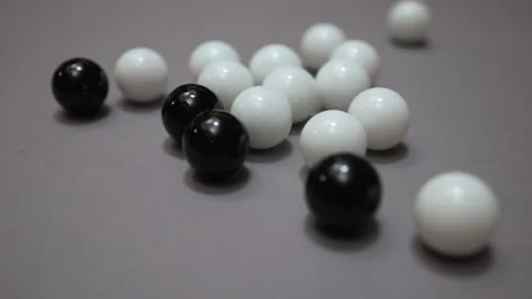 Group of black balls hitting white balls on gray surface Stock Footage 147106897