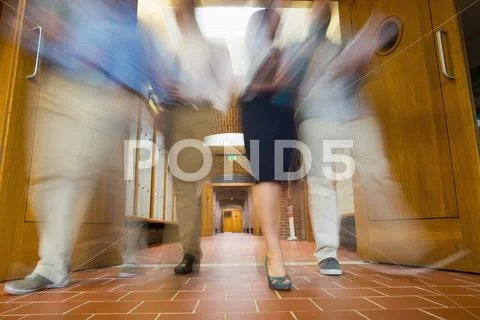 Group of blurred people walking through open doors Stock Photos