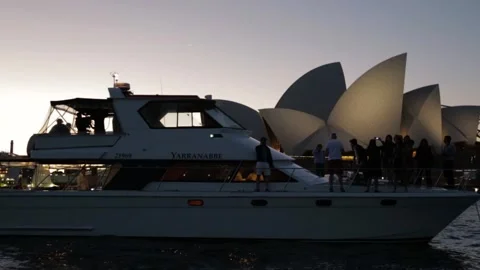 Group on Boat at Dusk with Landmark Building Illuminated in Sydney Harbor Stock Footage 345720296