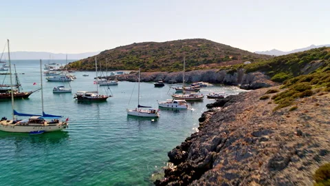 A group of boats are floating on top of a body of water near shores of Bodrum Stock Footage 269725864