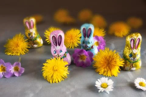 Group of branded Easter chocolate bunny figurines on a flowery table 库存照片