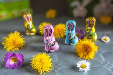 Group of branded Easter chocolate bunny figurines on a flowery table 库存照片