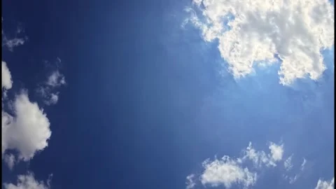 A group of bright white clouds in the sky moves slowly across the daytime sky Video stock 336648388