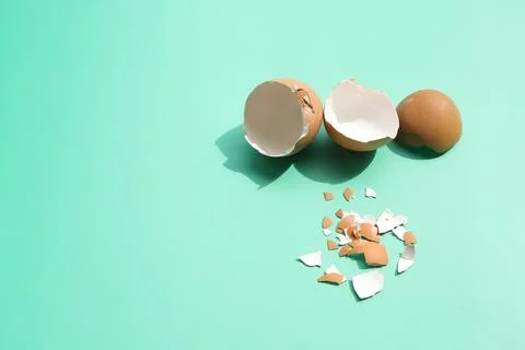 Group of broken egg shells on light green background.  Stock Photos