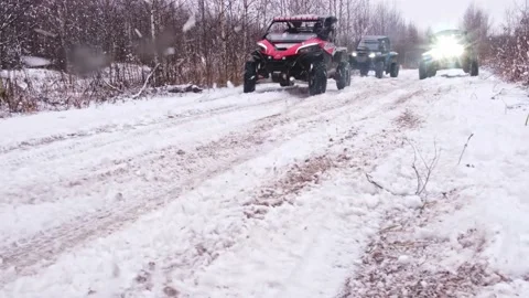 A group of buggies drives past the camera on a snowy road Stock Footage 188551677