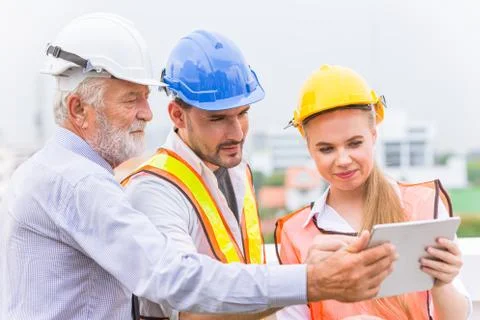 Group of builder engineer and architecture using new technology of tablet for Stock Photos