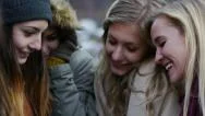 Group Of Bundled-Up Teen Girls Laughing At A Smart Phone Stock Footage