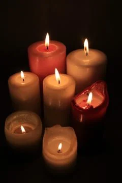 Group of burning candles in different heights and colors Stock-Fotos