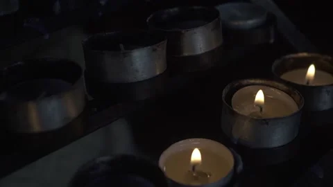 Group of burning tea light candles in a church. Some extinguished candle Stock Footage 170516092