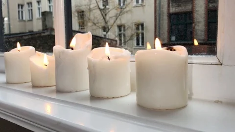 Group of burning white candles in window in winter Stock Footage 97446655