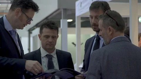 Group of business men talking over a catalog  Stock Footage 88545973