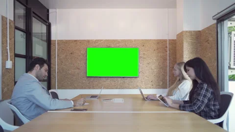 Group of business people meeting, presenting a project on TV blank green scre Stock Footage