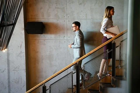 Group of business people walking and taking stairs in an office building Stock Photos