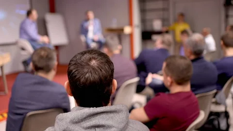 Group business trainer giving presentation to group of audience people. Male Stock Footage 166963684