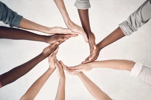 Group of businesspeople making a circle shape with their hands together in an Stock Photos