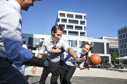Group Of Businesspeople Playing Basketball Outdoors