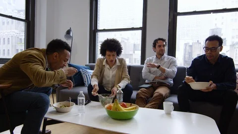 Group of businesspeople talking while having meal in office Stock Footage 93525454