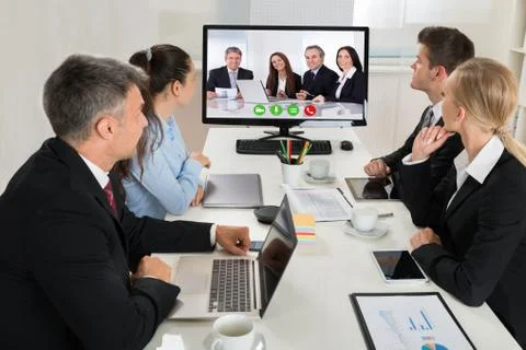 Group Of Businesspeople Watching An Online Presentation On A Desktop Computer Stock Photos