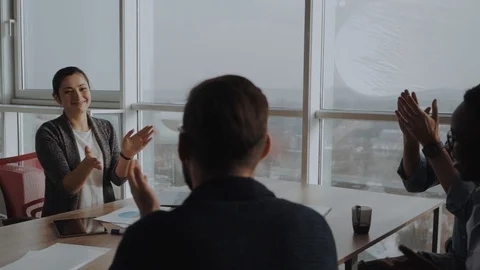 Group of businesspersons cheering and clapping for a co-worker at the office Vídeo Stock 99636611