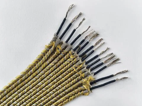 A group of cables lies on a flat surface. Each cable has a braided cover and  Stock Photos