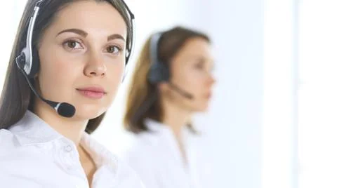 Group of call center operators at work. Focus at beautiful business woman in Stockfoto's