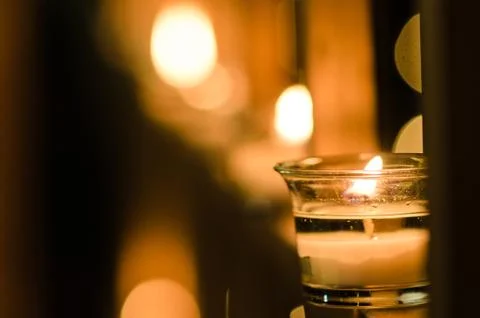 Group of candles in perspective in the light of night, emotional background w Stock Photos