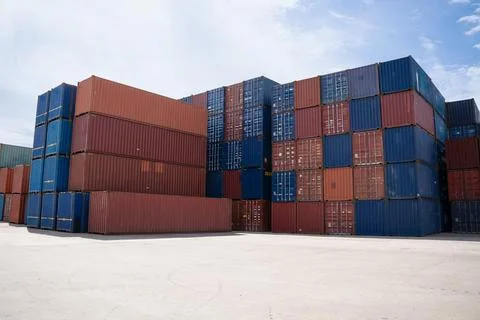 Group of cargo containers stacked in the terminal shipping yard. Stock Photos
