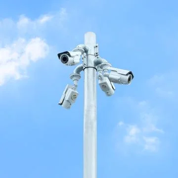 Group of CCTV on post with cloudy blue sky Foto stock