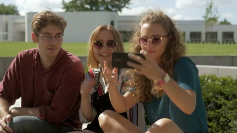 Group of cheerful friends taking a self portrait with a phone outdoors. Video stock 132549306